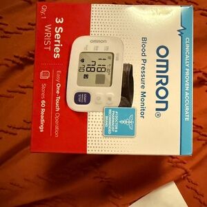 OMRON White and Black Wrist Blood Pressure Monitor with Blue Button Accent